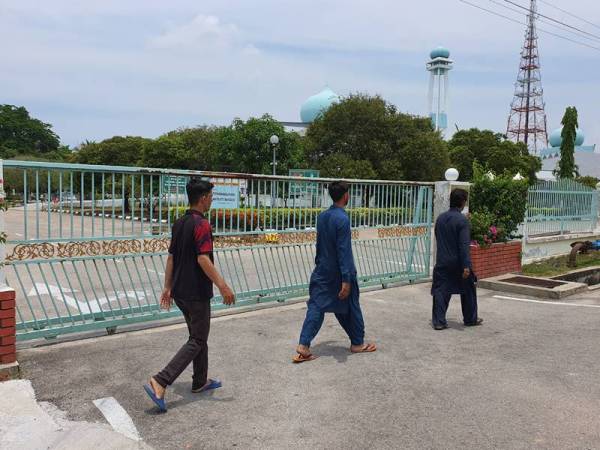 Kelihatan beberapa warga asing berjalan menuju ke masjid bagi menunaikan solat Jumaat.