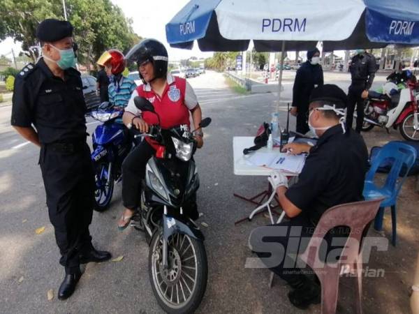 
Eng Lai (kiri) turut turun padang ketika sekatan jalan raya Perintah Kawalan Pergerakan berdekatan Melaka Sentral di sini hari ini.