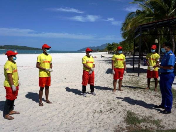 Azamshah menyampaikan taklimat kepada anggota penyelamat pantai APM sebelum melakukan pemantauan bagi memastikan pelancong mematuhi Perintah Kawalan Pergerakan ketika tinjauan di Pantai Chenang hari ini. - Foto Bernama