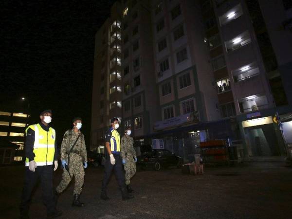 Anggota ATM dan PDRM melakukan rondaan di sekitar kawasan perumahan flat Taman Desa Jati, Nilai bagi memastikan rakyat mematuhi Perintah Kawalan Pergerakan (PKP). Foto: Bernama