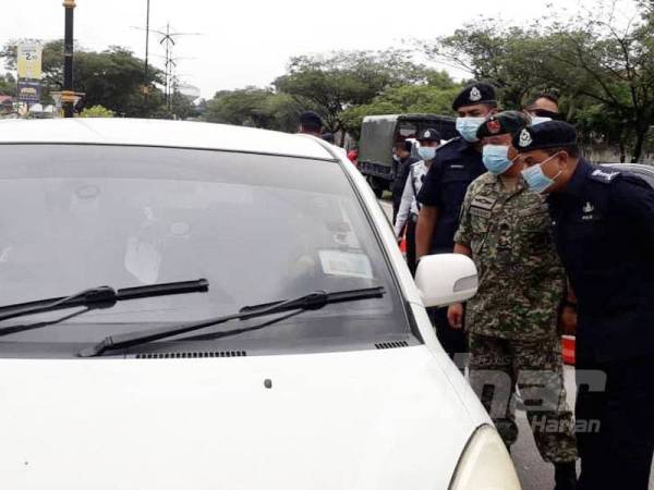 Ayob Khan (kanan) dan Zawai Adam melakukan pemeriksaan terhadap orang ramai dalam satu sekatan jalan raya yang dibuat pihak polis dengan kerjasama Angkatan Tentera Malaysia di Jalan Tampoi Lama, Johor Bahru, hari ini.