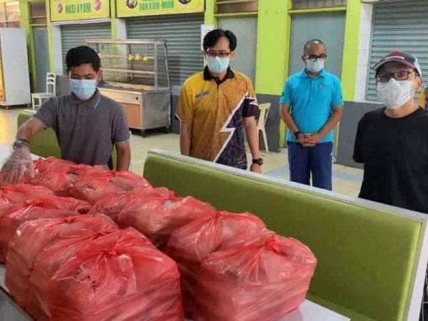 Dr Hendrik (dua dari kiri) memantau agihan bungkusan makanan untuk pelajar yang tidak pulang ke kampung halaman masing-masing. - Foto ihsan UUM