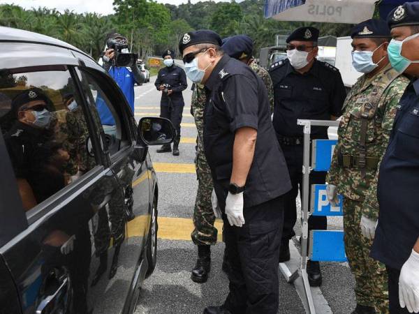 Ketua Polis Terengganu Datuk Roslee Chik (kiri) bertanyakan tujuan seorang pemandu keluar ketika Perintah Kawalan Pergerakan dikuatkuasa oleh kerajaan ketika meninjau sekatan jalan raya oleh anggota Polis bersama anggota Angkatan Tentera Malaysia (ATM) di Kilometer 83 Jalan Kuala Terengganu-Kota Bharu hari ini.