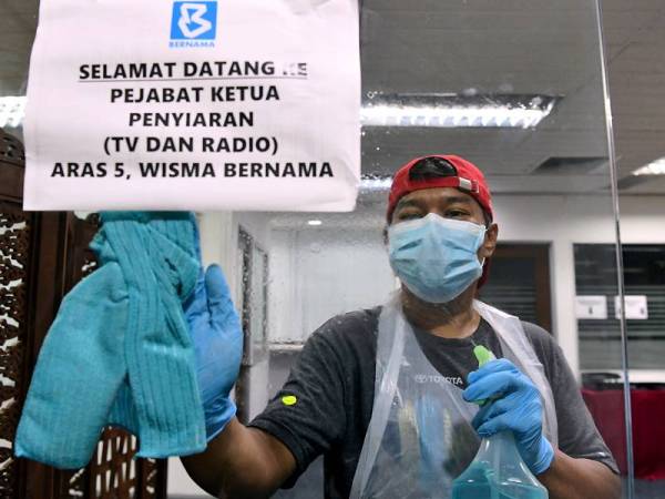 Kakitangan Pertubuhan Berita Nasional Malaysia (Bernama) melakukan kerja-kerja pembersihan di setiap ruang pejabat sebagai langkah pencegahan. - Foto Bernama