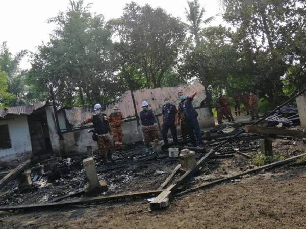 Azmi (kanan) ketika meninjau keadaan kebakaran sebuah rumah yang mengorbankan tiga beranak di Kampung Sungai Relong, Kamunting hari ini.