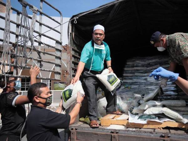 Ketua Pegawai Eksekutif LZNK, Zakaria Othman (tiga dari kiri) turut sama membantu mengagihkan beras yang akan diedarkan ke seluruh negeri Kedah.