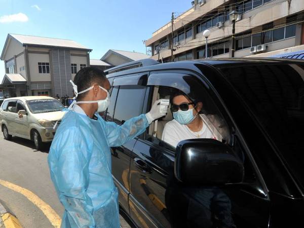 Petugas Jabatan Kesihatan Labuan membuat saringan kesihatan kepada penumpang feri Ro-Ro yang tiba di Labuan dari Menumbok, Sabah. -Foto Bernama