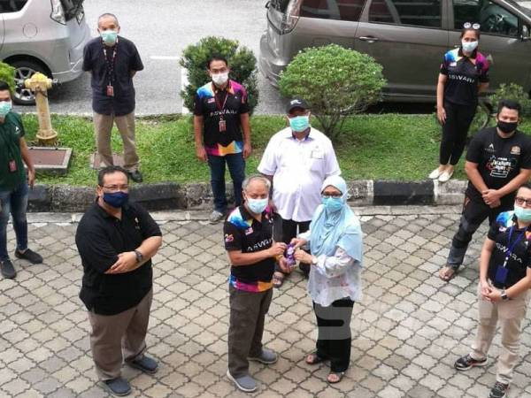 Muhammad Nasir (hadapan, dua dari kiri) menyerahkan sumbangan wang tunai kepada Raja Nor Sheela sambil diiringi Dr Sahar Sa'di (hadapan, kiri) dan pengurusan tertinggi Aswara hari ini.