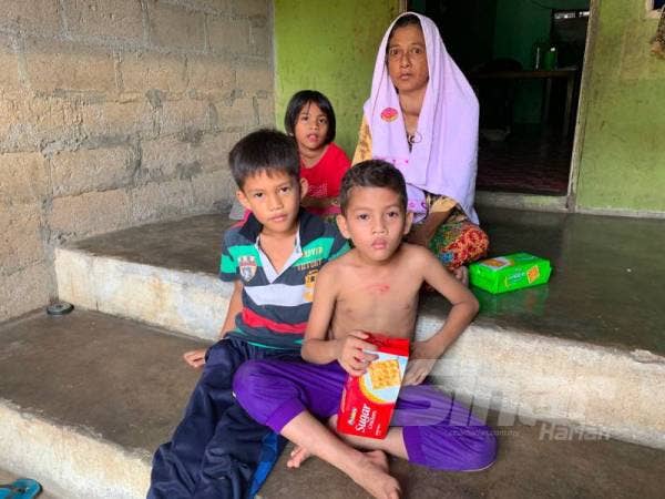 Aminah bersama cucunya berehat di tangga rumahnya sementara menunggu perkembangan semasa Covid-19.