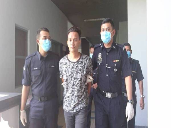 Mohamad Saiful Bahari (tengah) ketika dibawa keluar dari Mahkamah Majistret Ayer keroh, hari ini, kerana ingkar mematuhi arahan Perintah Kawalan Pergerakan (PKP).