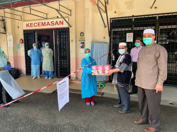 Mohd Amar menyerahkan makanan kepada petugas kesihatan di Klinik Jembal di sini.