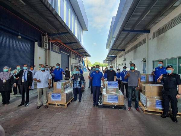 Selvakumar (tengah) bergambar bersama penerima sumbangan topeng muka.