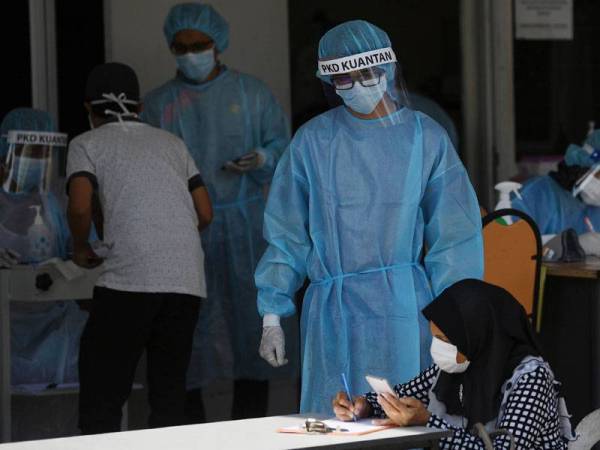 Barisan hadapan petugas giat mengambil sampel dan keterangan daripada individu yang datang untuk saringan COVID-19 hari ini. FOTO: BERNAMA