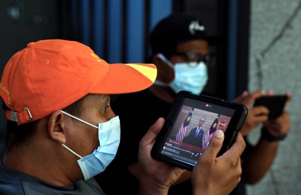 Orang awam mengikuti siaran langsung pengumuman Pakej Rangsangan Ekonomi Prihatin Rakyat. -Foto Bernama