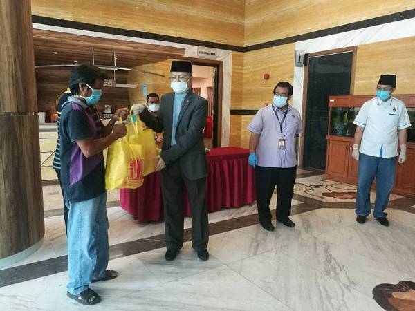 Mohammed semasa menyampaikan sumbangan kepada salah seorang penerima Baitulmal di Menara Mains di sini hari ini.