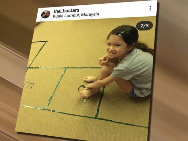 Salah seorang anak Que Haidsr tersenyum ketika bermain ting ting