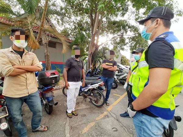 Dua lelaki bersama seorang warga Bangladesh sedang disoal oleh pegawai polis dalam Ops Covid-19 tadi.