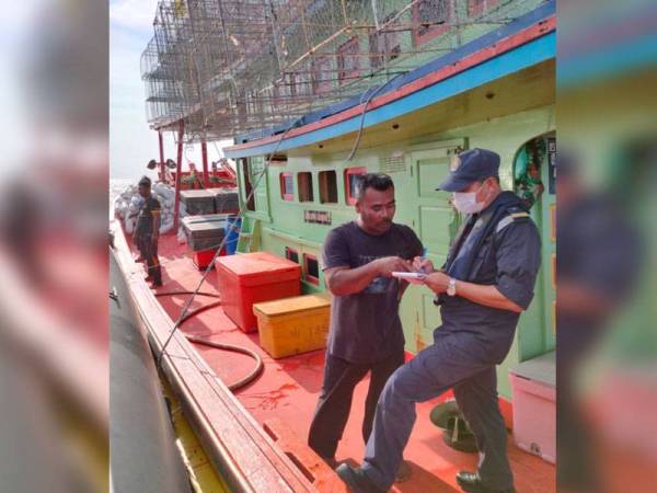 Salah seorang nelayan yang ditemukan selamat sedang disoal siasat oleh anggota APMM bertugas sejurus tiba di Jeti Kuala Kemaman, Terengganu (Foto: Ehsan APMM Terengganu).