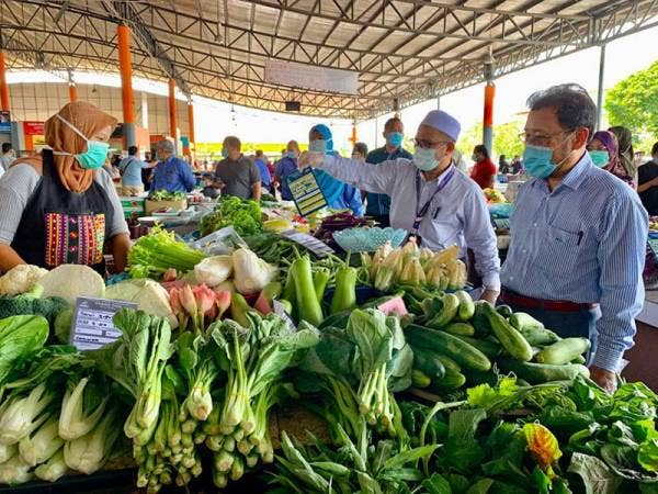 Che Abdullah (kanan) membuat tinjauan harga jualan di RTC Tunjong hari ini.