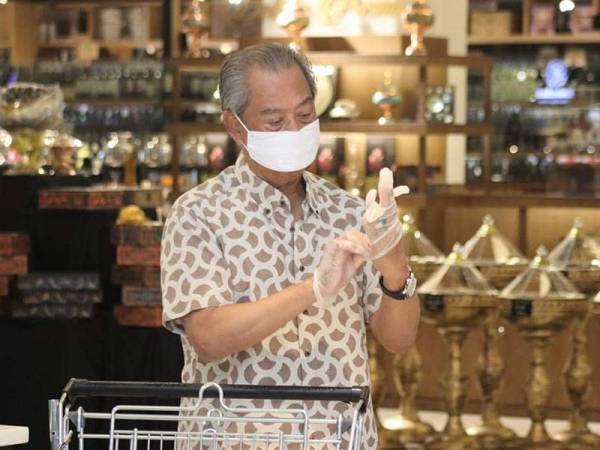 Muhyiddin memakai penutup hidung dan mulut serta sarung tangan sebagai langkah keselamatan dan perlindungan. -Foto: Facebook Muhyiddin Yassin