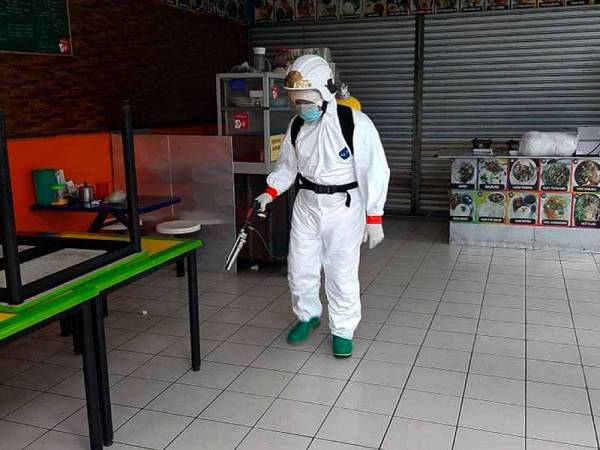 Anggota Bomba dan Penyelamat melakukan kerja-kerja nyahcemar di tiga pasaraya di Simpang Renggam dekat Kluang. - Foto Bernama