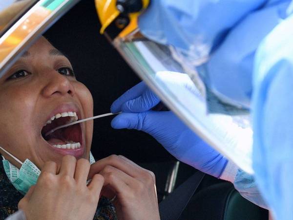 Kakitangan Hospital Pakar KPJ Damansara mengendalikan ujian mudah alih pandu lalu Covid-19. - Foto Bernama