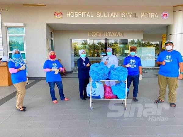 Muhammad Arief (dua dari kanan) bersama rakannya daripada Briged Negaraku Kelantan menyerahkan 1,000 tudung dan sarung kasut kepada petugas barisan hadapan di Hospital Sultan Ismail Petra, Kuala Krai.