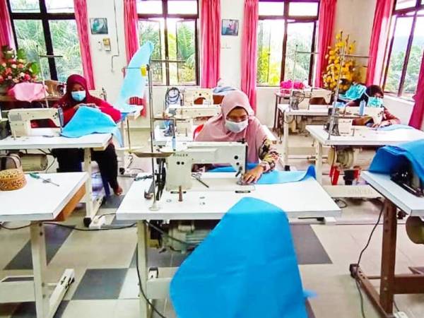 Sukarelawan Kemas di Kelas Jahitan Kemas Gali Tengah, Raub sedang menyediakan baju makmal pakai buang untuk kegunaan petugas-petugas hospital sekitar Pahang.