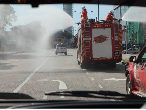 Anggota bomba menggunakan jentera untuk melakukan semburan nyah cemar pada Operasi Sanitasi Awam Covid-19 sekitar bandar Kuantan, hari ini.
