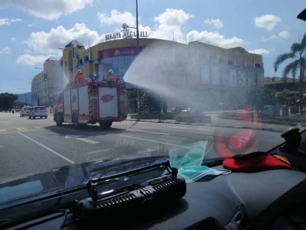 Anggota bomba menggunakan jentera untuk melakukan semburan nyah cemar pada Operasi Sanitasi Awam Covid-19 sekitar bandar Kuantan, hari ini.