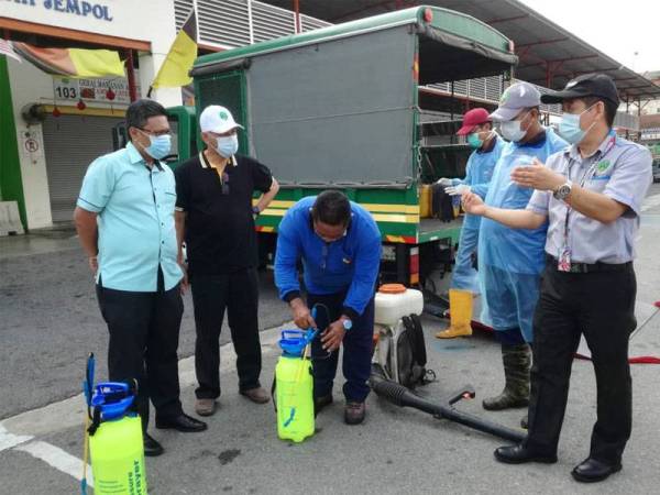 Shahrul Nizam (kiri), Raja Norazli (dua dari kiri) ketika mendengar penerangan berhubung Operasi Nyah kuman di Bahau hari ini.