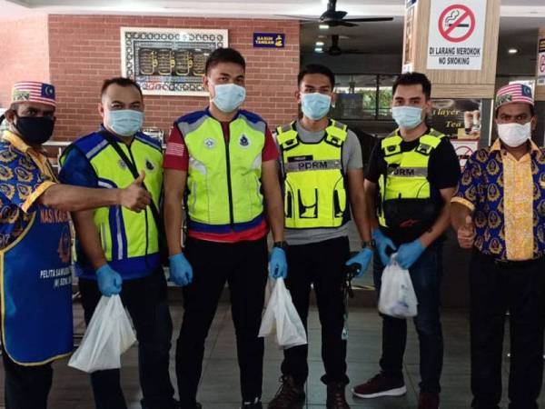 Kakitangan Pelita Nasi Kandar menyampaikan pek makanan percuma kepada anggota polis yang bertugas.