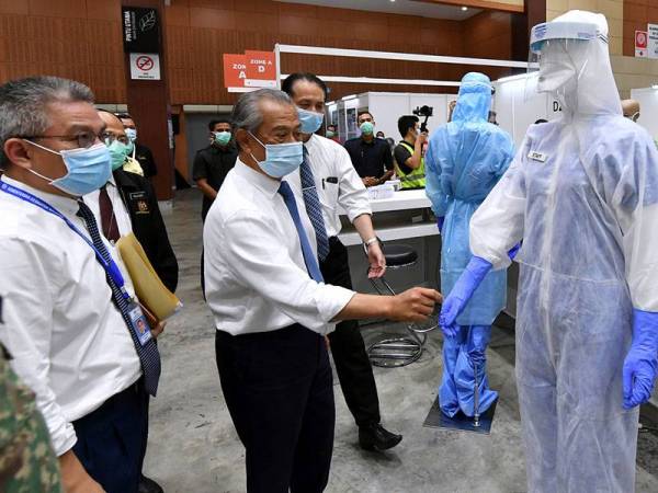 Perdana Menteri Tan Sri Muhyiddin Yassin meninjau kerja-kerja menyiapkan Pusat Kuarantin dan Rawatan COVID-19 Berisiko Rendah di Taman Ekspo Pertanian Malaysia Serdang (MAEPS) hari ini. - Foto Bernama