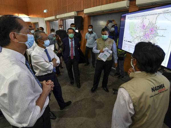 Perdana Menteri Tan Sri Muhyiddin Yassin (dua, kiri) diberi penerangan semasa meninjau kerja-kerja menyiapkan Pusat Kuarantin dan Rawatan COVID-19 Berisiko Rendah di Taman Ekspo Pertanian Malaysia Serdang (MAEPS) hari ini. - Foto Bernama