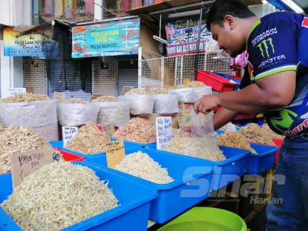 Mumammad Irfan Danial memberikan tawaran harga terhadap jualan ikan bilis mata biru bagi memastikan bekalan diperolehi dapat dihabiskan.
