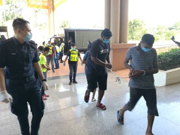 Tertuduh diiringi anggota polis ketika dibawa untuk mendengar sebutan kes di Mahkamah Majistret di sini hari ini.