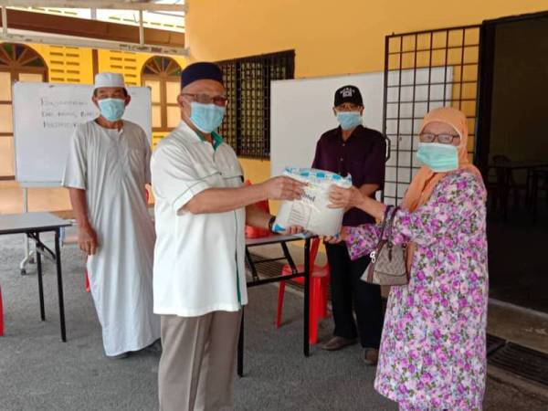 Rafie semasa menyampaikan bantuan kepada penduduk di Kampung Mertang Galau semalam.