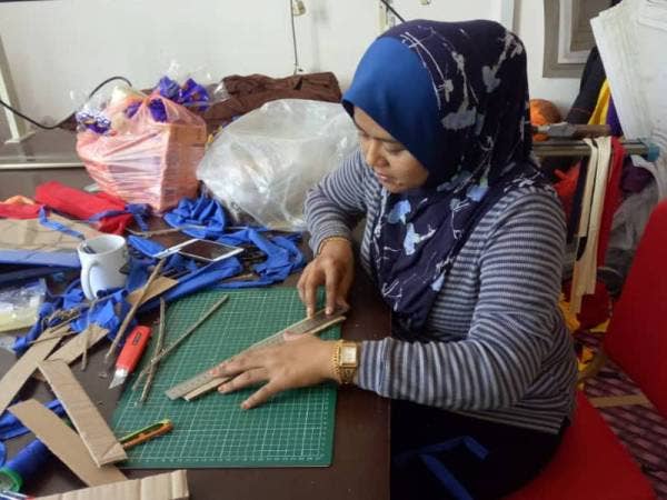 Sukarelawan menyiapkan alat pelindung muka