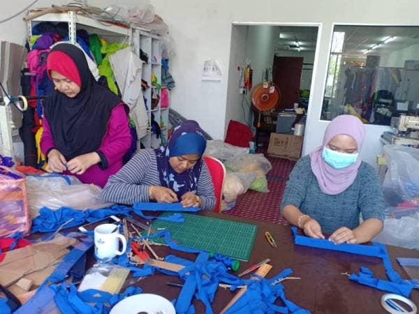 Sukarelawan menyiapkan alat pelindung muka