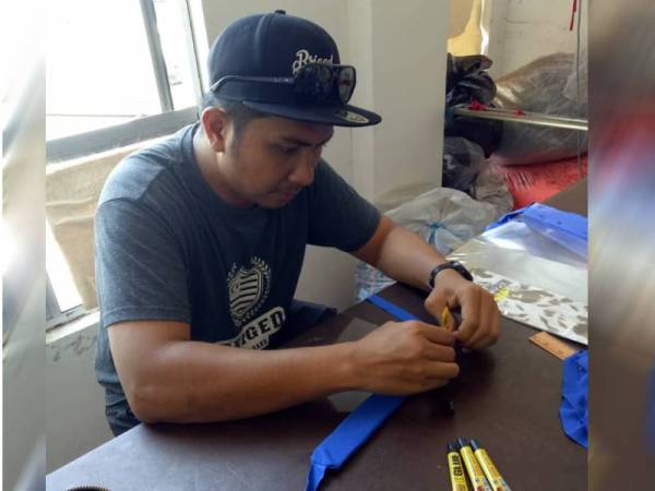 Sukarelawan menyiapkan alat pelindung muka