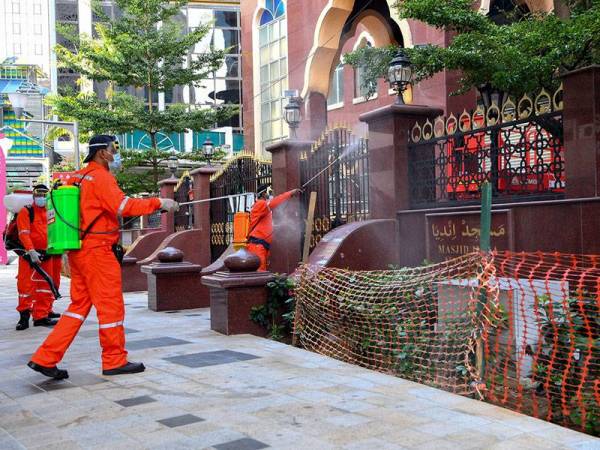 Petugas dari Unit Kesihatan Majlis Bandaraya Kuala Lumpur (DBKL) melakukan kerja-kerja semburan sanitasi di sekitar kawasan Masjid Jamek ketika tinjauan hari ini. - Foto Bernama
