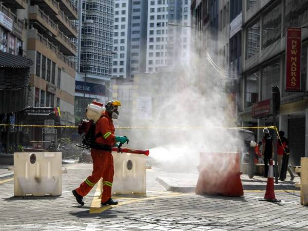 Pegawai Dewan Bandaraya Kuala Lumpur melakukan semburan ketika Operasi Pembersihan Disinfeksi di sekitar Jalan Tunku Abdul Rahman. - Bernama