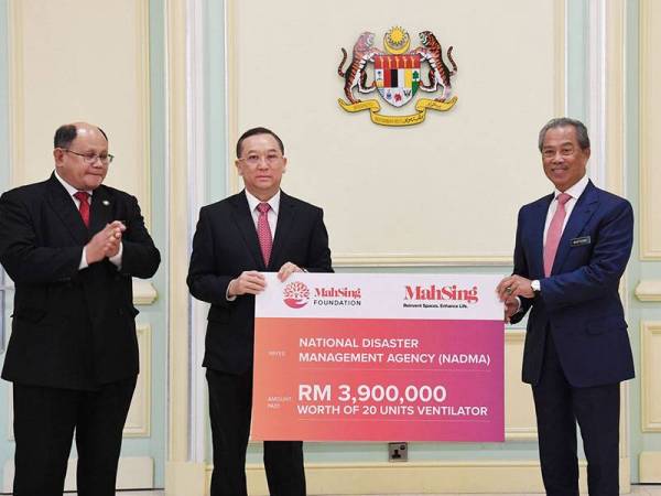 Perdana Menteri Tan Sri Muhyiddin Yassin (kanan) menerima sumbangan daripada Pengarah Urusan Kumpulan Mah Sing Tan Sri Leong Hoy Kum (dua, kiri) pada Majlis Penyerahan Sumbangan Tabung COVID-19 dari sektor korporat di Bangunan Perdana Putra hari ini. - Foto Bernama