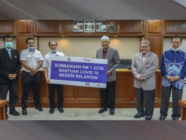 Ahmad (tiga dari kanan) menerima sumbangan tersebut daripada wakil TNB. - GAMBAR IHSAN UKMB