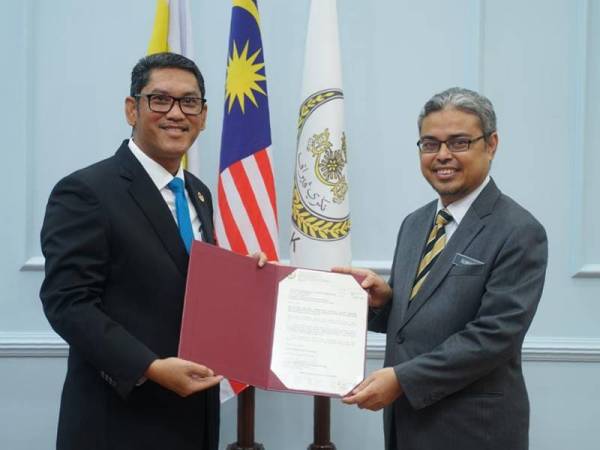 Ahmad Faizal (kiri) menyampaikan surat pelantikan sebagai Datuk Bandar Ipoh kepada Rumaizi di Pejabat Menteri Besar Perak di sini hari ini.