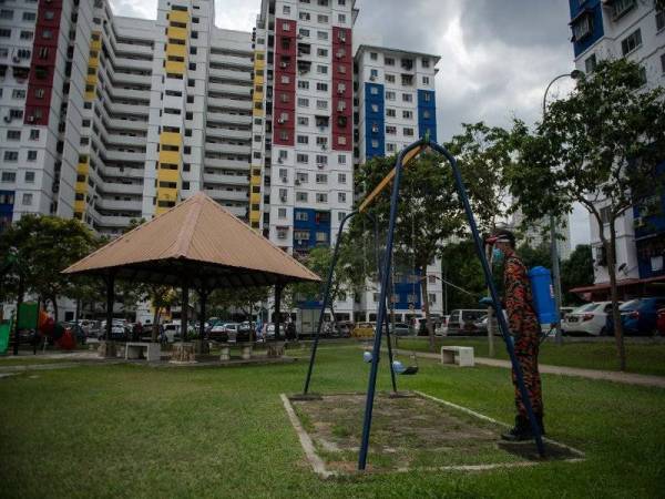Anggota Bomba dan Penyelamat menjalankan proses penyahkuman atau disinfeksi ketika Operasi Pembersihan Disinfeksi di Projek Perumahan Rakyat (PPR) Kerinchi, Lembah Pantai hari ini. Foto: Bernama