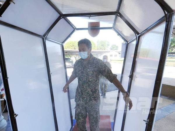 Seorang anggota tentera melalui alat virus buster yang dihasilkan hasil inovasi pihak 12 Briged dalam usaha membasmi wabak Covid-19. - Foto Sinar Harian ROSLI TALIB