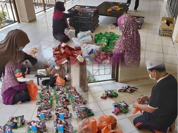 Petugas menyediakan makanan untuk diagihkan kepada pelajar