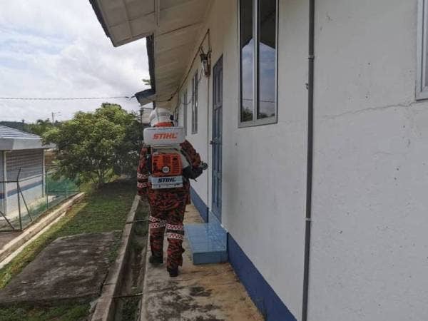 Anggota bomba melakukan Operasi Sanitasi Awam di Balai Polis Pagoh, Muar, Johor, hari ini bagi mencegah penularan Covid-19 di tempat-tempat tumpuan awam.