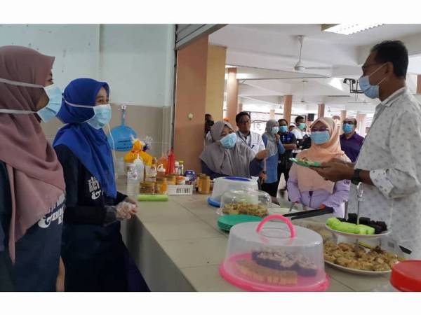 Rosol (kanan) mencuba makanan disediakan sukarelawan untuk pelajar UMT yang tinggal di sana sepanjang tempoh PKP berlangsung.